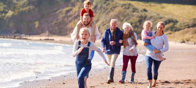 Familie in Wales am Strand Eine große Familie läuft am Strand