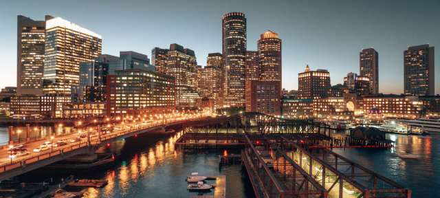 Boston Skyline Eine Stadt mit vielen Gebäuden und Booten im Vordergrund