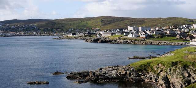 Bizarre Klippen, archaische Natur: Shetland Islands Ein kleines Dorf an der Küste mit vielen Häusern
