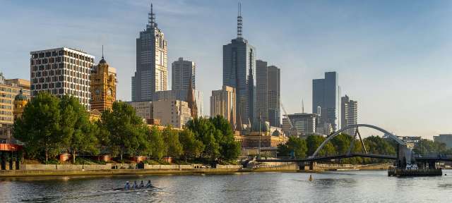 Yarra River und Skyline von Melbourne Eine Gruppe von Menschen in einem Ruderboot auf einem Fluss in der Stadt