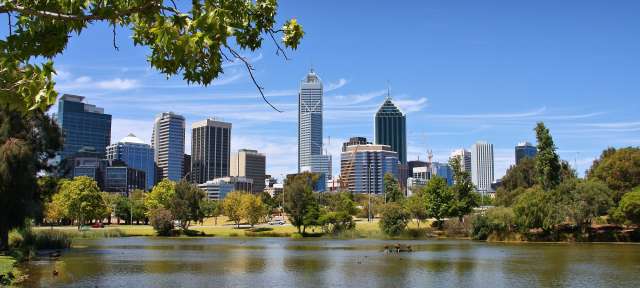 Einsamste Großstadt Australiens: Perth Eine Stadtlandschaft mit einem See und Bäumen im Vordergrund