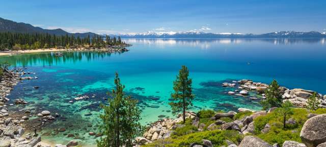Saphirblaues Wasser: Lake Tahoe Ein See mit Bäumen und Felsen im Vordergrund
