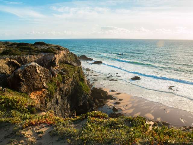 Eine Klippe mit Blick auf einen Strand und das Meer