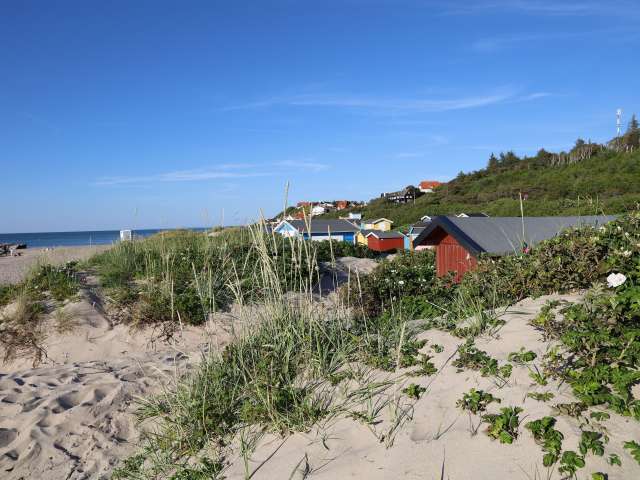 Ein Strand mit bunten Hütten im Hintergrund