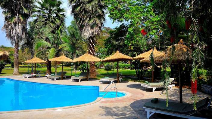 Liegestühle und Sonnenschirme umgeben einen großen Swimmingpool