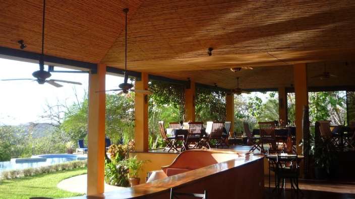Ein Restaurant mit Tisch und Stühlen und Deckenventilatoren
