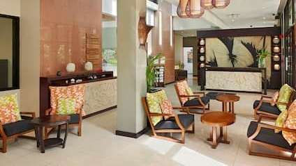 Ein Wohnzimmer mit Stühlen , Tischen und Lampen .