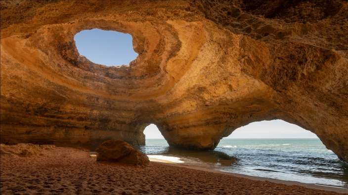 Eine Höhle am Strand mit einem Loch in der Decke