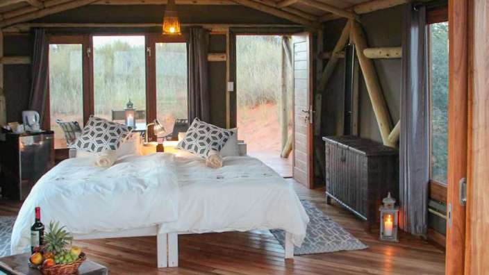 Ein Zimmer mit einem Bett und vielen Fenstern
