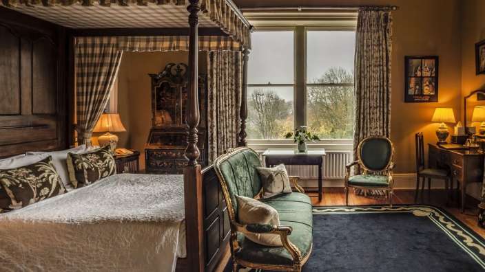 Ein Schlafzimmer mit einem Himmelbett und einem Fernseher