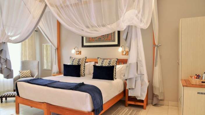 Ein Schlafzimmer mit Himmelbett und blauen Kissen