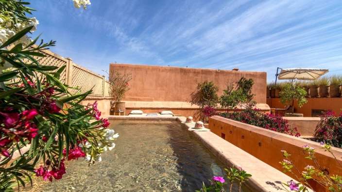 Ein großer Pool mit einem roten Gebäude im Hintergrund