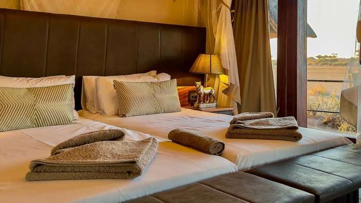 Ein Schlafzimmer mit zwei Betten und einer Lampe