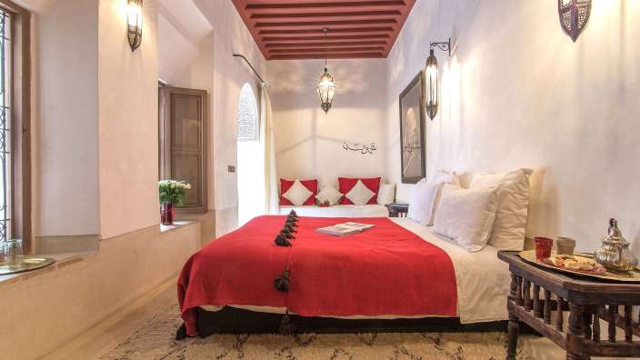 Ein Schlafzimmer mit einem roten Bett und einem weißen Teppich