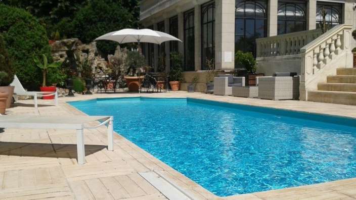 Ein großer Swimmingpool mit einem weißen Regenschirm darauf