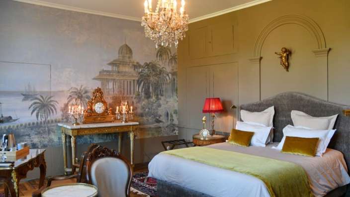 Ein Schlafzimmer mit einem großen Bett und einem Kronleuchter