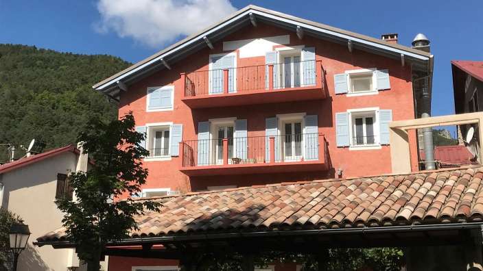 Ein großes rotes Haus mit blauen Fensterläden