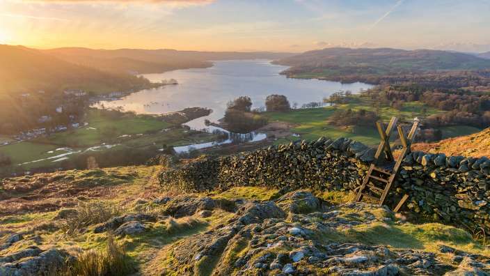 Ein Blick auf einen See mit einer Steinmauer im Vordergrund