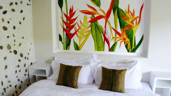 Ein Schlafzimmer mit einem Gemälde an der Wand über dem Bett