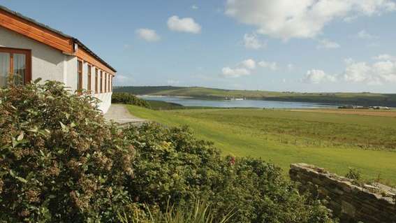 Ein Haus mit Blick auf einen See und ein Feld