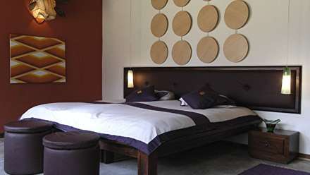 Ein Schlafzimmer mit einem Bett und zwei Hockern