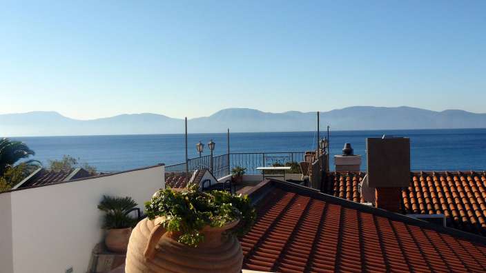 Ein Balkon mit Blick auf das Meer und die Berge