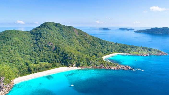 Eine Insel mit einem weißen Strand und einem blauen Ozean