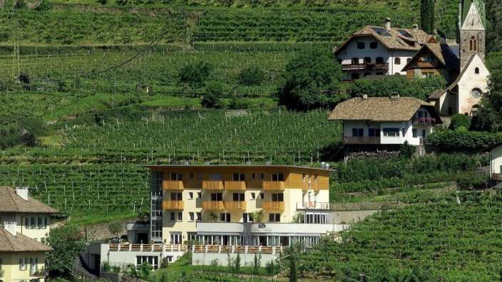Ein Gebäude auf einem Hügel mit Blick auf einen Weinberg