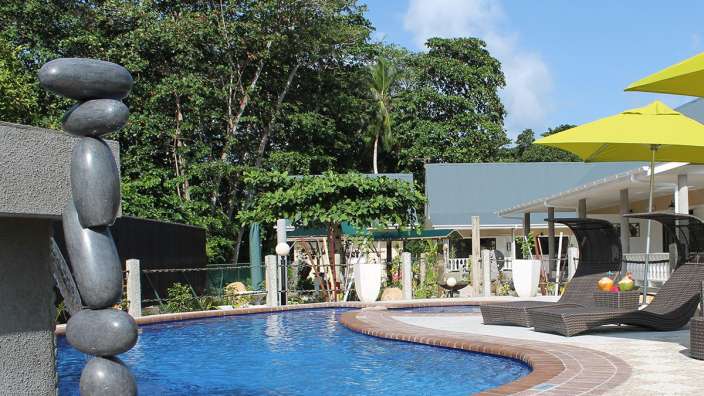 Ein großer Swimmingpool mit Liegestühlen und Sonnenschirmen