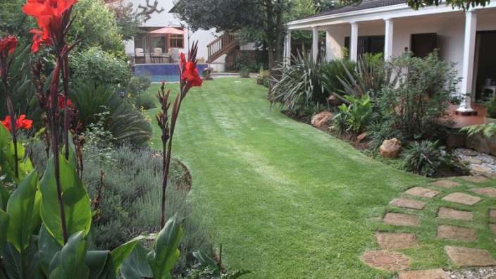 Ein garten mit blumen und einem haus im hintergrund