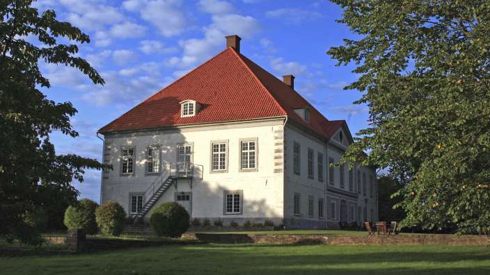 Ein großes weißes Gebäude mit einem roten Dach