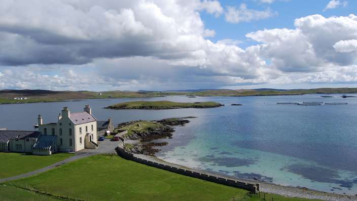 Ein großes weißes Haus steht am Ufer eines großen Gewässers