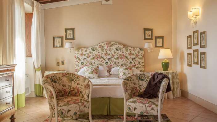 Ein Schlafzimmer mit einem Bett und zwei Stühlen