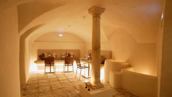 Ein Raum mit Tischen und Stühlen und einem Steinsäulen