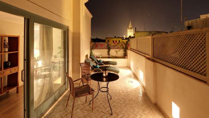 Ein Balkon mit einem Tisch und Stühlen in der Nacht