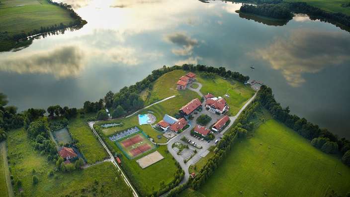 Eine Luftaufnahme eines Sees mit einem kleinen Gebäude in der Mitte