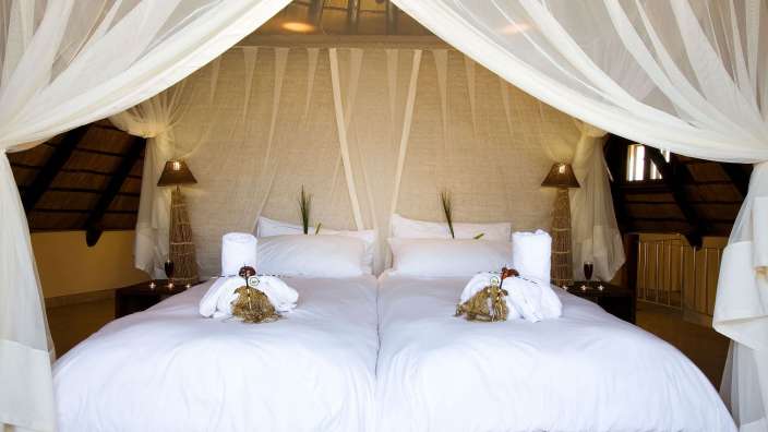 Ein Schlafzimmer mit zwei Betten und weißen Vorhängen
