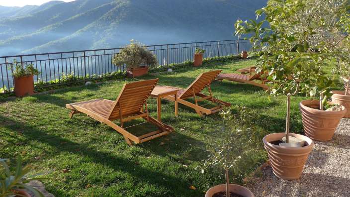 Liegestühle auf einer Wiese mit Blick auf die Berge