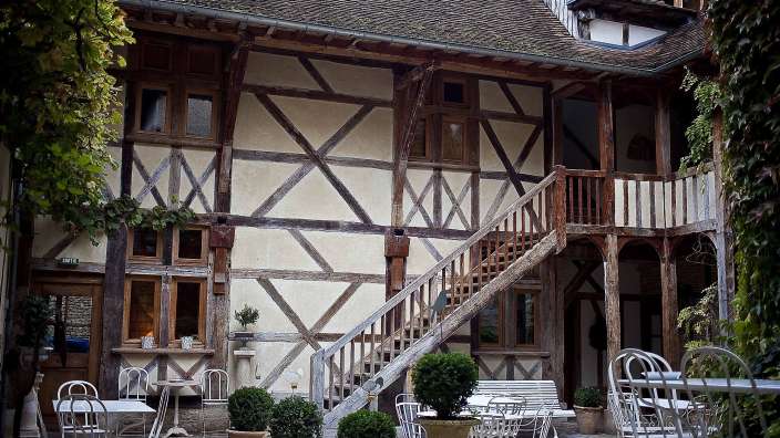 Ein Gebäude mit einer Treppe und einem Tisch und Stühlen davor