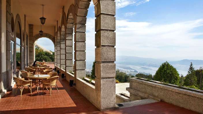 Tische und Stühle auf einer Terrasse mit Blick auf einen Fluss