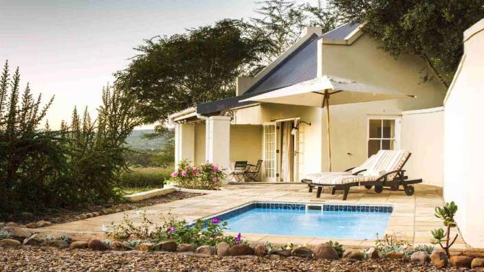 Ein kleines Haus mit einem kleinen Pool davor