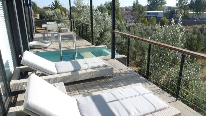 Ein Deck mit Liegestühlen und einem kleinen Pool