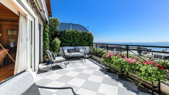 Ein Balkon mit einer Couch und Stühlen und einem Tisch