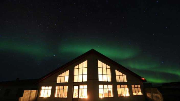 Ein Haus mit vielen Fenstern beleuchtet in der Nacht