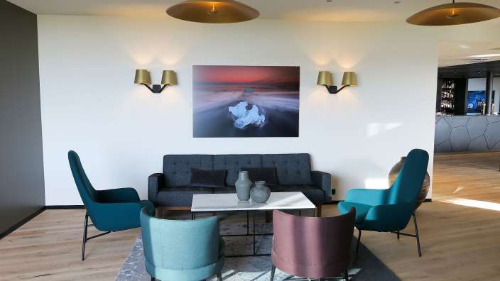 Ein Wohnzimmer mit einer Couch und Stühlen und einem Gemälde an der Wand