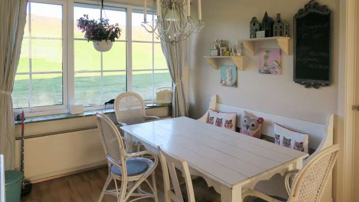 Ein Esszimmer mit einem weißen Tisch und Stühlen