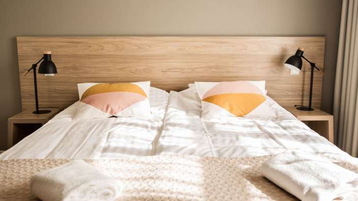 Ein Bett mit zwei Lampen und zwei Kissen darauf