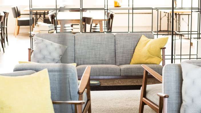 Ein Wohnzimmer mit Couch und Stühlen mit gelben Kissen