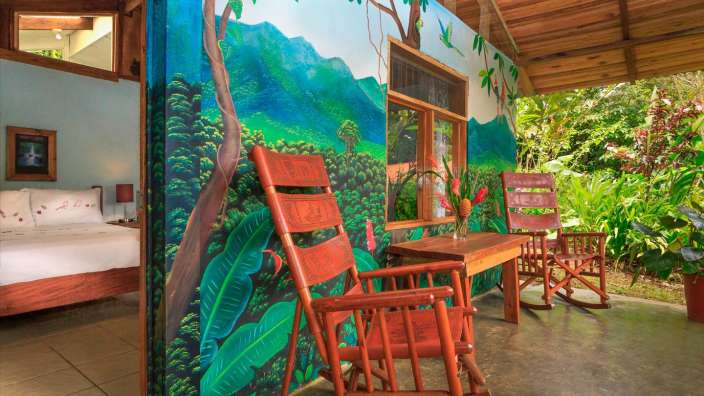 Ein Zimmer mit einem Gemälde an der Wand und zwei Schaukelstühlen