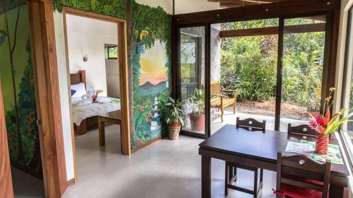 Ein Zimmer mit einem Tisch und Stühlen und einem Gemälde an der Wand